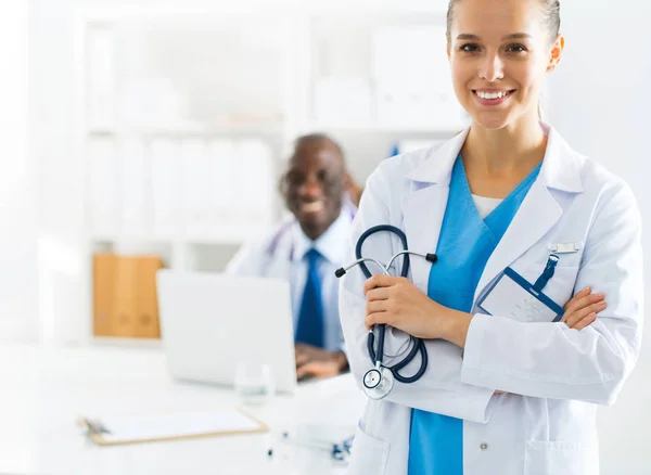 Una doctora sonriente con una carpeta en uniforme en el interior — Foto de Stock