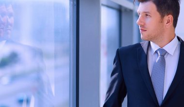 Koridorda pencere yakınındaki şirketi ayakta başarılı iş adamı