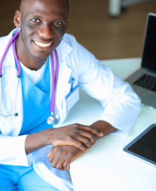 Masada dizüstü bilgisayarda çalışan genç bir Afrikalı doktor.