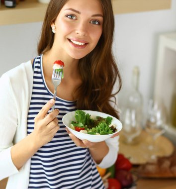 Salata yemek ve karışık salata tutan genç kadın