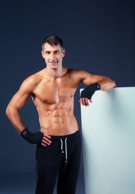 Güçlü atletik adam siyah arka plan üzerine kurulu yanında ayakta