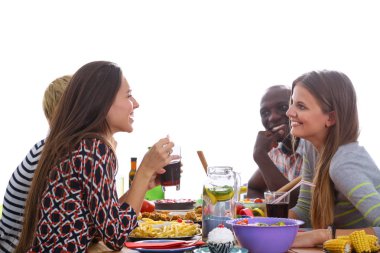 Bir grup insan ahşap masada otururken birlikte yemek yiyorlar.