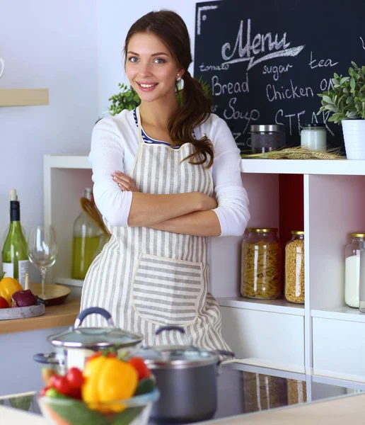 Giovane donna in piedi vicino alla scrivania in cucina — Foto Stock