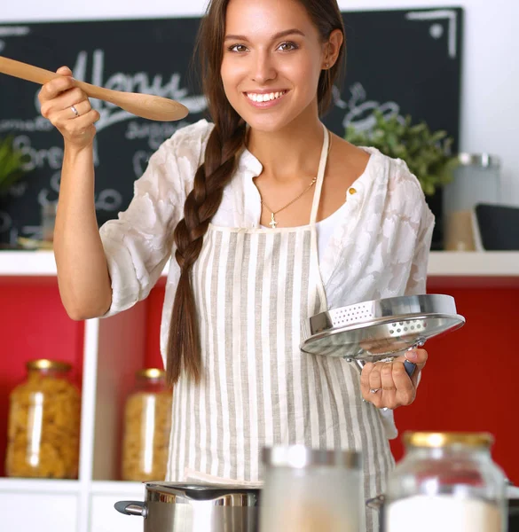 Koken vrouw in keuken met houten lepel — Stockfoto
