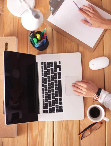 Jeune femme travaillant assise à un bureau — Photo