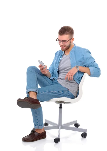 Young man sitting on chair and using mobile phone — Stock Photo, Image