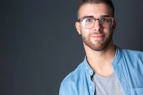 Retrato de homem casual feliz de pé isolado em um fundo escuro — Fotografia de Stock