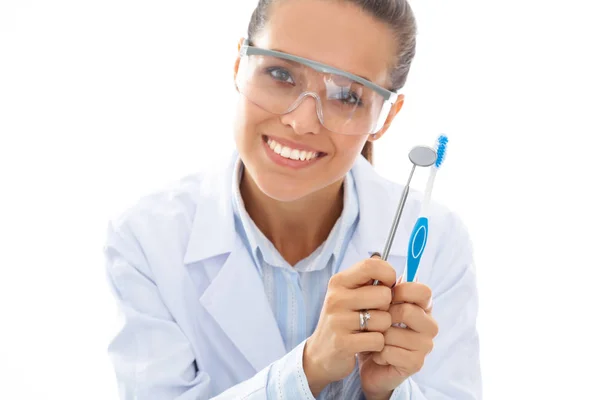 漂亮的女牙医，手持并展示白色背景的牙刷 — 图库照片