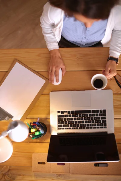 Jeune femme travaillant assise à un bureau — Photo