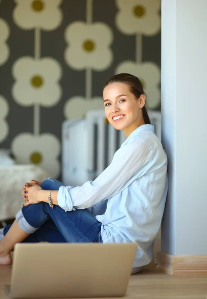 Jonge mooie vrouw thuis zittend op de vloer met laptop — Stockfoto