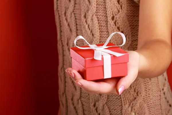Young woman is standing while holding a bag of gifts over her shoulder Stock Image