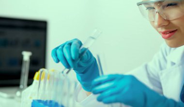 Kadın araştırmacı, beyaz arka planda izole edilmiş ilaç şişeleri ve mataralarla çevrili.