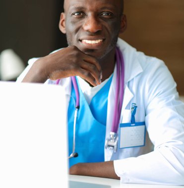 Masada dizüstü bilgisayarda çalışan genç bir Afrikalı doktor.