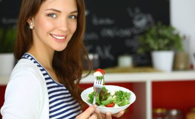 Salata yemek ve karışık salata tutan genç kadın