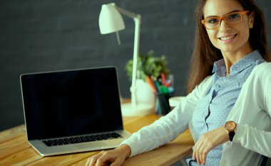 Masada oturan genç bir kadın.