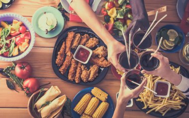 Yemek masasında içki içen insanlar.