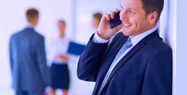 Ofiste cep telefonunu kullanan bir iş adamı.