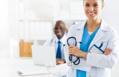 İçerde üniforması olan gülümseyen bir kadın doktor.