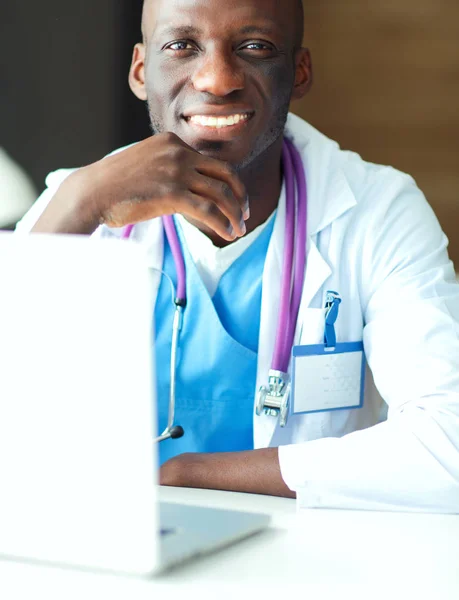 Masada dizüstü bilgisayarda çalışan genç bir Afrikalı doktor. — Stok fotoğraf