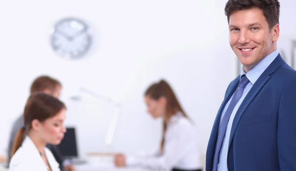 Uomo d'affari di successo in piedi con il suo personale in background in ufficio — Foto Stock