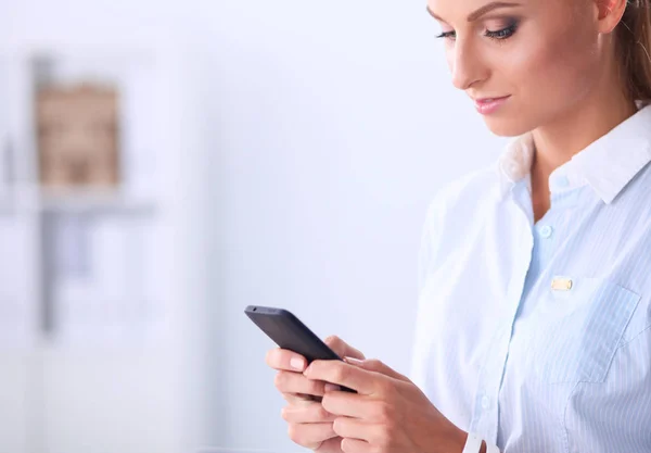 Geschäftsfrau verschickt Nachricht mit Smartphone im Büro — Stockfoto