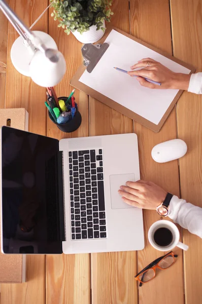 Jeune femme travaillant assise à un bureau — Photo