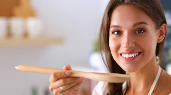 Cooking woman in kitchen with wooden spoon