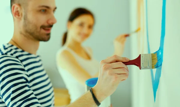 Pareja joven pintando pared en casa —  Fotos de Stock