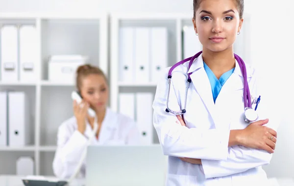 Portrait of young woman doctor with white coat standing in hospital — Stock Photo, Image