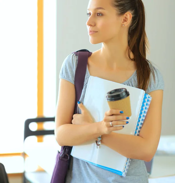 Lachende student met mappen en kopje koffie — Stockfoto