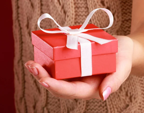 Young woman is standing while holding a bag of gifts over her shoulder — Stock Photo, Image