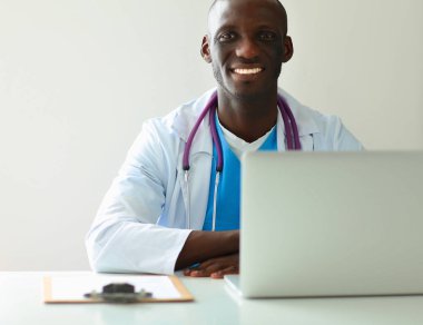 Masada dizüstü bilgisayarda çalışan genç bir Afrikalı doktor.