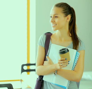 Egzersiz kitap tutan bir genç öğrenci kadın portresi.