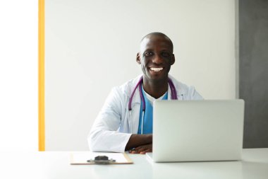 Masada dizüstü bilgisayarda çalışan genç bir Afrikalı doktor.