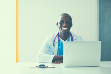 Masada dizüstü bilgisayarda çalışan genç bir Afrikalı doktor.