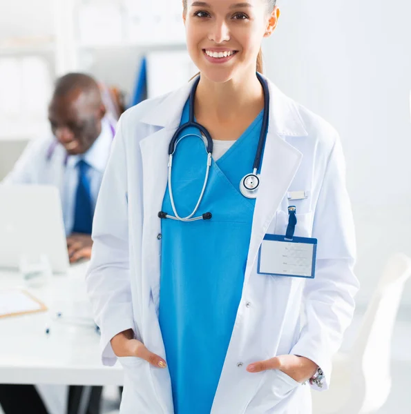 Una doctora sonriente con una carpeta en uniforme en el interior — Foto de Stock