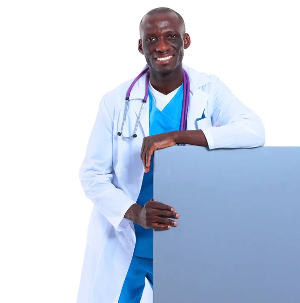 Maschio medico in possesso di cartello vuoto in piedi su sfondo bianco — Foto Stock