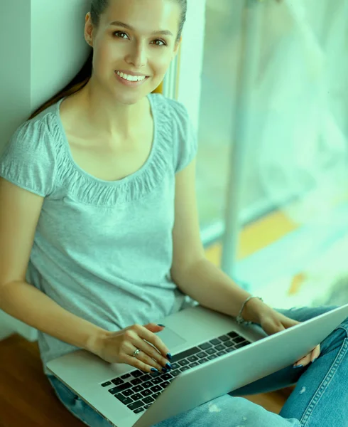 Jeune belle femme en utilisant un ordinateur portable à la maison — Photo