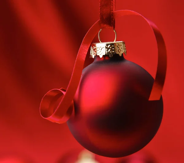 Röda julgranskulor på en skål, på röd bakgrund — Stockfoto