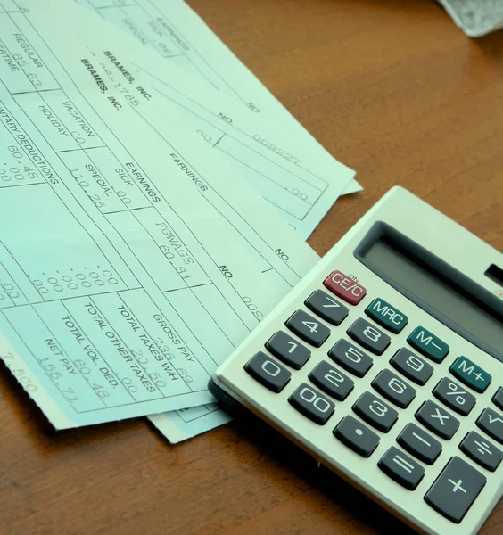 Калькулятор с деловой бумагой на столе — стоковое фото