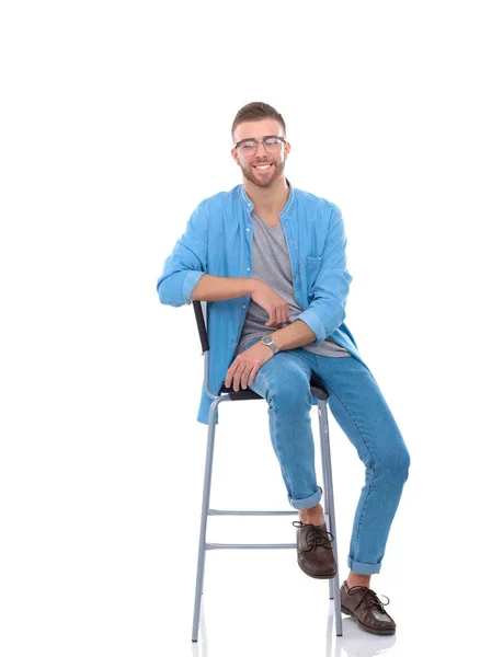 Young man sitting on the chair isolated over white background — Stock Photo, Image