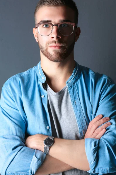 Retrato de homem casual feliz de pé isolado em um fundo escuro — Fotografia de Stock