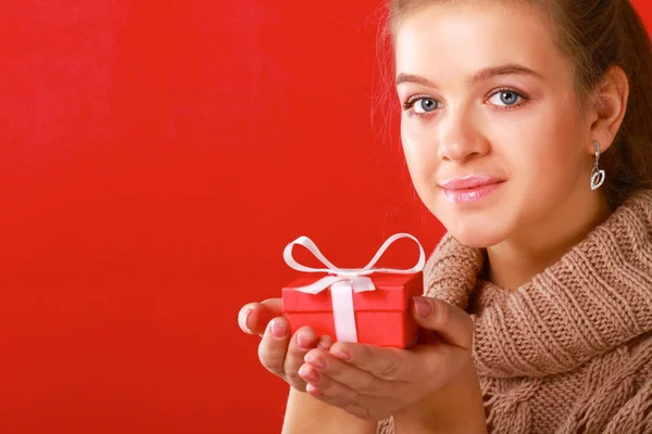 Mujer joven está de pie mientras sostiene una bolsa de regalos sobre su hombro —  Fotos de Stock