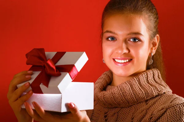 Young woman is standing while holding a bag of gifts over her shoulder — Stock Photo, Image