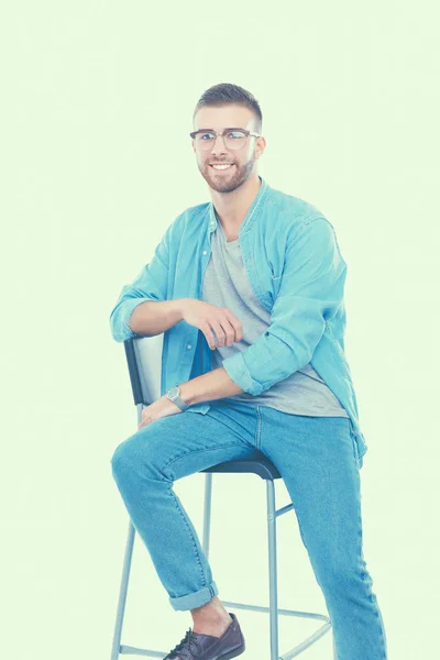 Beyaz arka plan üzerinde izole sandalye üzerinde oturan genç adam — Stok fotoğraf