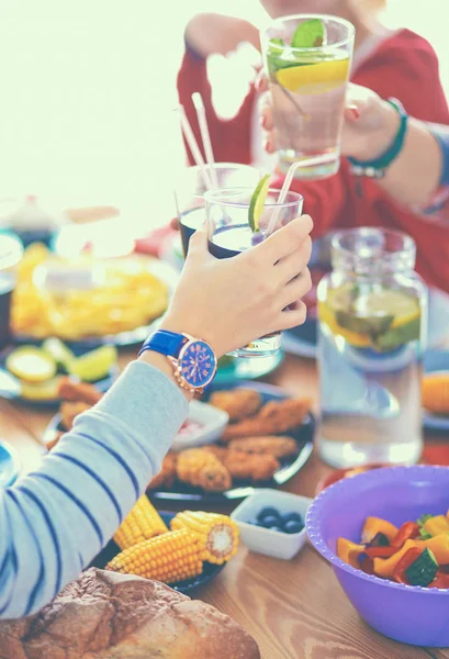 Pessoas com bebidas enquanto se sentam na mesa de jantar — Fotografia de Stock