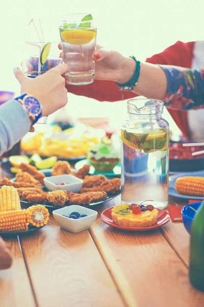 Pessoas com bebidas enquanto se sentam na mesa de jantar — Fotografia de Stock