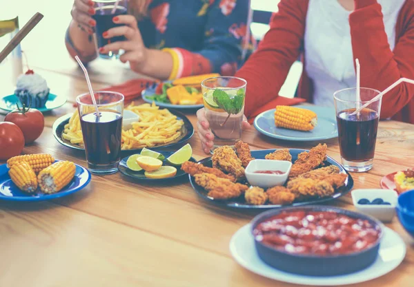 Gruppe von Menschen beim gemeinsamen Abendessen am Holztisch — Stockfoto