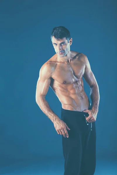 Сильный спортсмен, стоящий на черном фоне — стоковое фото