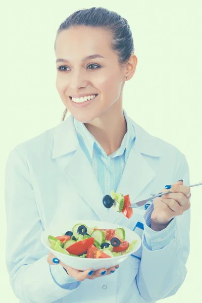 Portret van dokter van de mooie vrouw houdt van een plaat met verse groenten. — Stockfoto